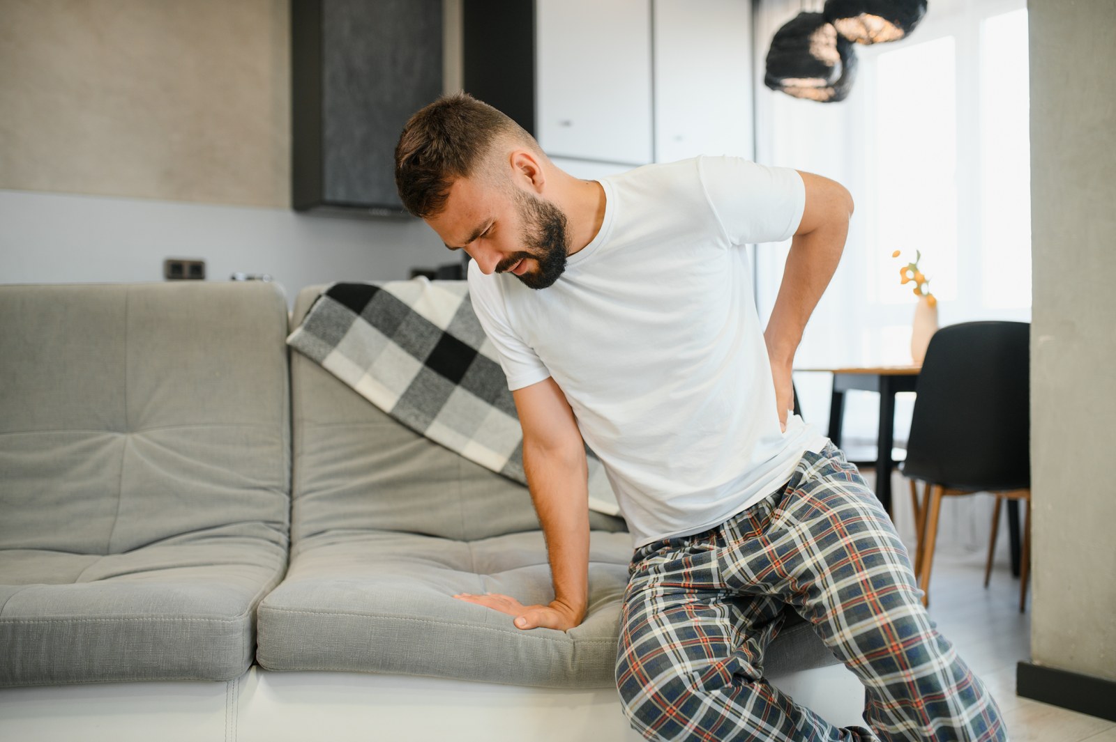 Man with lower back pain in the morning at home, back pain relief Greenville SC, Organic Mechanics